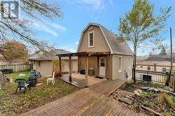 Back of property with a pergola, a wooden deck, and a fire pit - 