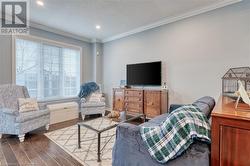 Living room with dark hardwood / wood-style floors, crown molding, and a textured ceiling - 