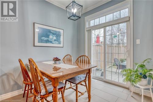 Tiled dining space featuring a notable chandelier and crown molding - 26 Summerberry Way, Hamilton, ON - Indoor Photo Showing Dining Room