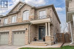 View of front facade featuring a balcony and a garage - 