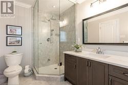 Bathroom with tile patterned floors, vanity, a shower with door, and crown molding - 