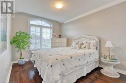 Bedroom featuring a textured ceiling, dark hardwood / wood-style floors, and crown molding - 