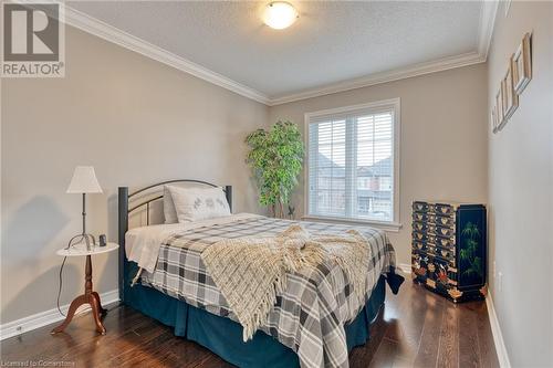 Bedroom featuring dark hardwood / wood-style flooring, a textured ceiling, and ornamental molding - 26 Summerberry Way, Hamilton, ON - Indoor Photo Showing Bedroom