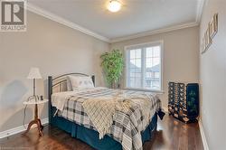 Bedroom featuring dark hardwood / wood-style flooring, a textured ceiling, and ornamental molding - 