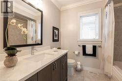 Full bathroom featuring vanity, shower / bath combo, crown molding, tile patterned flooring, and toilet - 