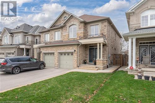 View of front of property featuring a balcony, a front yard, and a garage - 26 Summerberry Way, Hamilton, ON - Outdoor With Facade