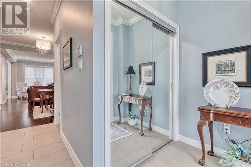 Hallway featuring an inviting chandelier, ornamental molding, a textured ceiling, and light wood-type flooring - 26 Summerberry Way, Hamilton, ON - Indoor Photo Showing Other Room