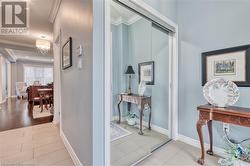 Hallway featuring an inviting chandelier, ornamental molding, a textured ceiling, and light wood-type flooring - 