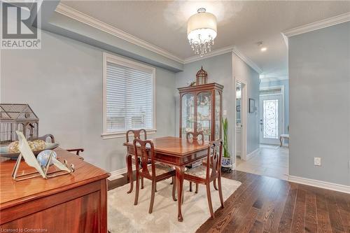 Dining area featuring crown molding, an inviting chandelier, a textured ceiling, and hardwood / wood-style flooring - 26 Summerberry Way, Hamilton, ON - Indoor Photo Showing Dining Room