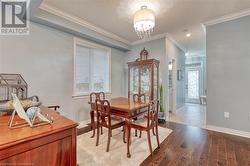 Dining area featuring crown molding, an inviting chandelier, a textured ceiling, and hardwood / wood-style flooring - 