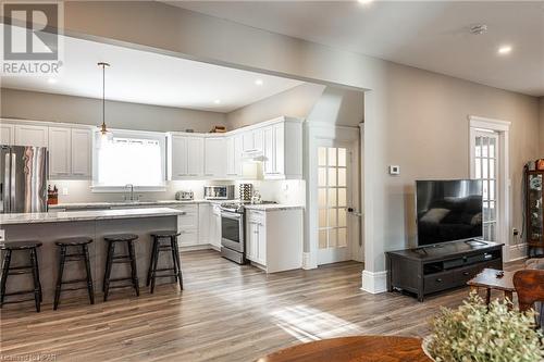 Kitchen featuring hanging light fixtures, white cabinets, stainless steel appliances, and light hardwood / wood-style floors - 175 Mcnab St, Stratford, ON - Indoor Photo Showing Other Room