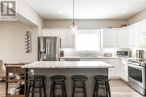 Kitchen with appliances with stainless steel finishes, sink, light hardwood / wood-style flooring, white cabinets, and a kitchen island - 175 Mcnab St, Stratford, ON - Indoor Photo Showing Kitchen With Upgraded Kitchen