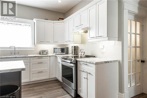 Kitchen with white cabinetry, dark wood-type flooring, stainless steel appliances, and sink - 175 Mcnab St, Stratford, ON - Indoor Photo Showing Kitchen With Upgraded Kitchen