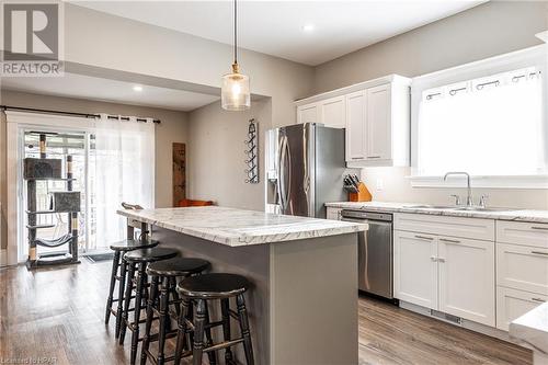 Kitchen with light wood-type flooring, stainless steel appliances, white cabinets, a center island, and hanging light fixtures - 175 Mcnab St, Stratford, ON - Indoor Photo Showing Kitchen With Upgraded Kitchen