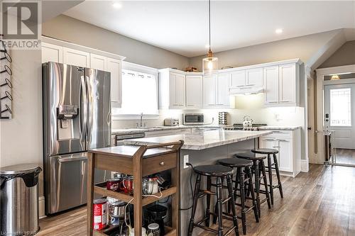 Kitchen featuring white cabinetry, hanging light fixtures, dark wood-type flooring, and appliances with stainless steel finishes - 175 Mcnab St, Stratford, ON - Indoor Photo Showing Kitchen