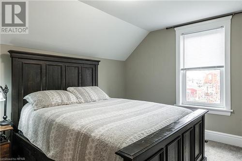 Bedroom with lofted ceiling, carpet floors, and multiple windows - 175 Mcnab St, Stratford, ON - Indoor Photo Showing Bedroom