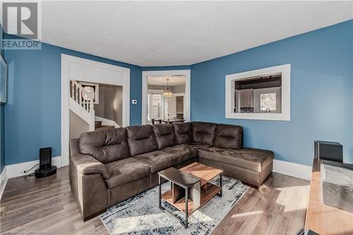 Living room featuring hardwood / wood-style floors, a textured ceiling, and an inviting chandelier - 20 Sarah Street, Brantford, ON - Indoor Photo Showing Living Room