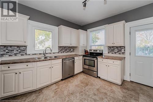 Kitchen with stainless steel appliances, white cabinetry, a healthy amount of sunlight, and sink - 20 Sarah Street, Brantford, ON - Indoor Photo Showing Kitchen With Double Sink