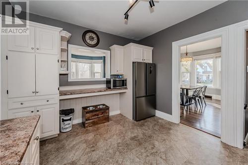 Kitchen featuring white cabinetry, appliances with stainless steel finishes, and light hardwood / wood-style flooring - 20 Sarah Street, Brantford, ON - Indoor Photo Showing Other Room