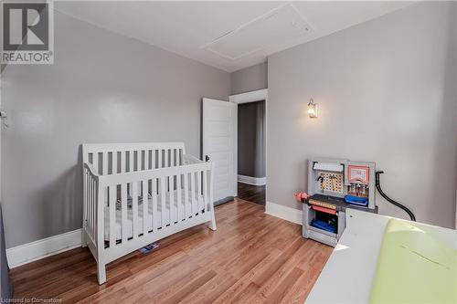 Bedroom featuring hardwood / wood-style floors and a nursery area - 20 Sarah Street, Brantford, ON - Indoor Photo Showing Bedroom