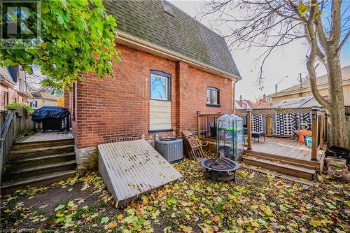 Rear view of house featuring central air condition unit, a wooden deck, and a fire pit - 20 Sarah Street, Brantford, ON - Outdoor With Deck Patio Veranda With Exterior