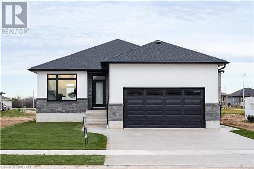 View of front of property with a front yard and a garage - 323 Mclean Crescent, Saugeen Shores, ON - Outdoor