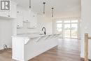 Kitchen featuring light wood-type flooring, sink, a center island with sink, white cabinets, and hanging light fixtures - 323 Mclean Crescent, Saugeen Shores, ON  - Indoor Photo Showing Kitchen 