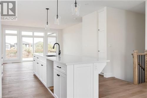 Kitchen featuring pendant lighting, light hardwood / wood-style floors, sink, and an island with sink - 323 Mclean Crescent, Saugeen Shores, ON - Indoor Photo Showing Other Room