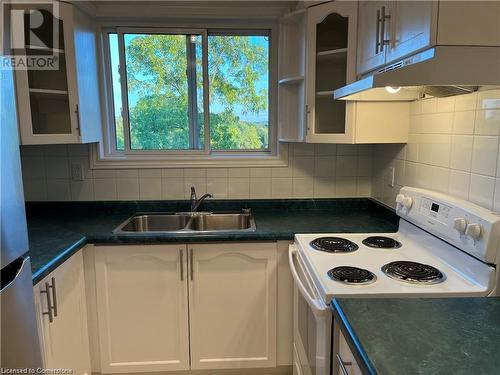 Kitchen featuring stainless steel fridge, tasteful backsplash, white range with electric stovetop, sink, and white cabinetry - 2373 King Street E Unit# 48, Hamilton, ON - Indoor Photo Showing Kitchen With Double Sink