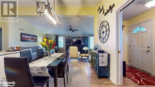 Dining room with lofted ceiling, light hardwood / wood-style flooring, and ceiling fan with notable chandelier - 69 St James Place, Wasaga Beach, ON - Indoor