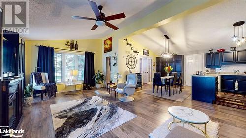 Living room with hardwood / wood-style flooring, ceiling fan with notable chandelier, lofted ceiling, and sink - 69 St James Place, Wasaga Beach, ON - Indoor