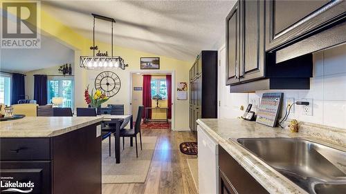 Kitchen with white dishwasher, light hardwood / wood-style flooring, vaulted ceiling, and a wealth of natural light - 69 St James Place, Wasaga Beach, ON - Indoor Photo Showing Kitchen