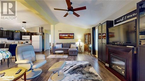 Living room with ceiling fan, dark hardwood / wood-style flooring, lofted ceiling, and sink - 69 St James Place, Wasaga Beach, ON - Indoor Photo Showing Living Room With Fireplace