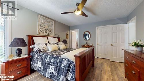 Bedroom featuring ceiling fan, light hardwood / wood-style floors, and a textured ceiling - 69 St James Place, Wasaga Beach, ON - Indoor Photo Showing Bedroom