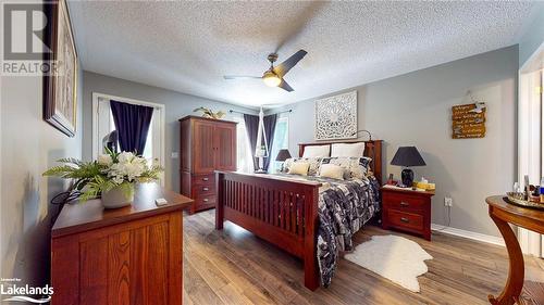 Bedroom featuring a textured ceiling, hardwood / wood-style flooring, and ceiling fan - 69 St James Place, Wasaga Beach, ON - Indoor Photo Showing Bedroom