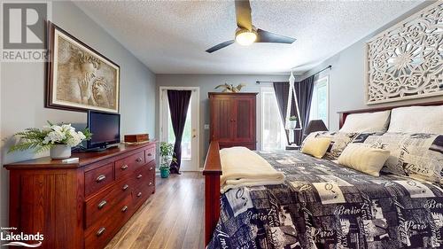 Bedroom featuring multiple windows, a textured ceiling, light hardwood / wood-style flooring, and ceiling fan - 69 St James Place, Wasaga Beach, ON - Indoor Photo Showing Bedroom