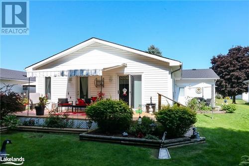 Rear view of house with a lawn and a wooden deck - 69 St James Place, Wasaga Beach, ON - Outdoor