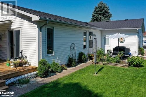 Rear view of property with a wooden deck and a lawn - 69 St James Place, Wasaga Beach, ON - Outdoor