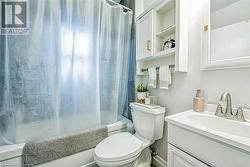 Full bathroom featuring vanity, toilet, and shower / tub combo with curtain - 