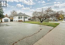 View of front of property with an outdoor structure, a front yard, and a garage - 