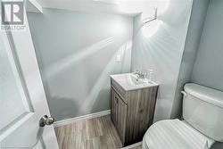 Bathroom with hardwood / wood-style flooring, vanity, and toilet - 