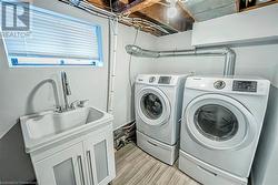 Clothes washing area featuring washer and dryer and light wood-type flooring - 