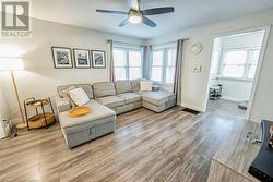 Living room featuring ceiling fan and light hardwood / wood-style floors - 