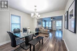 Dining space with ceiling fan with notable chandelier and dark hardwood / wood-style floors - 