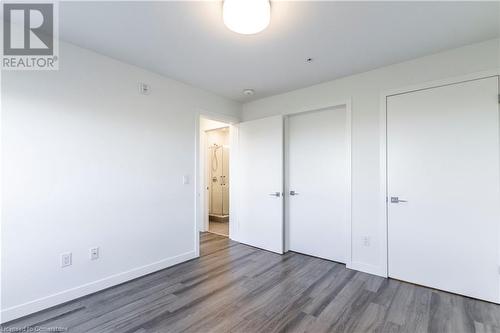 Unfurnished bedroom featuring wood-type flooring - 479 Charlton Avenue E Unit# 404, Hamilton, ON - Indoor Photo Showing Other Room