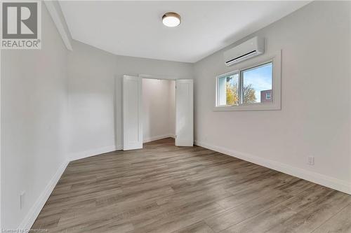 Bedroom in the ADU featuring a closet, a wall mounted air conditioner, and light wood-type flooring - 306 Paling Avenue, Hamilton, ON - Indoor Photo Showing Other Room