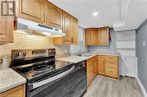 Kitchen with sink, electric range, decorative backsplash, light wood-type flooring, and black dishwasher - 306 Paling Avenue, Hamilton, ON - Indoor Photo Showing Kitchen