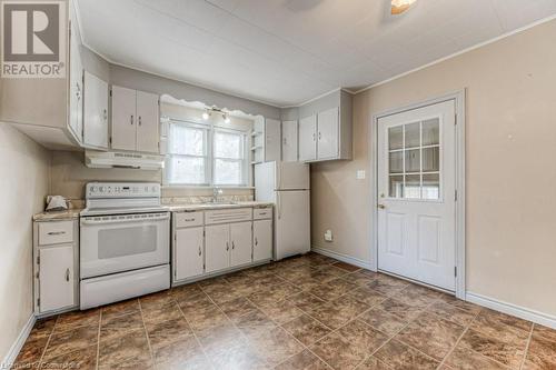 Kitchen with white appliances, white cabinetry, crown molding, and sink - 55 Ellis Avenue, Kitchener, ON - Indoor Photo Showing Kitchen