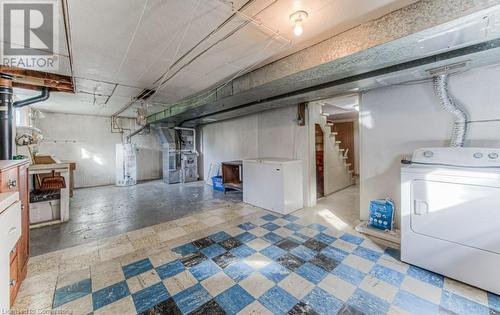 Basement with white fridge, gas water heater, washer / clothes dryer, and heating unit - 55 Ellis Avenue, Kitchener, ON - Indoor Photo Showing Laundry Room