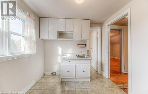 Kitchen with white cabinetry, sink, and light hardwood / wood-style floors - 55 Ellis Avenue, Kitchener, ON - Indoor